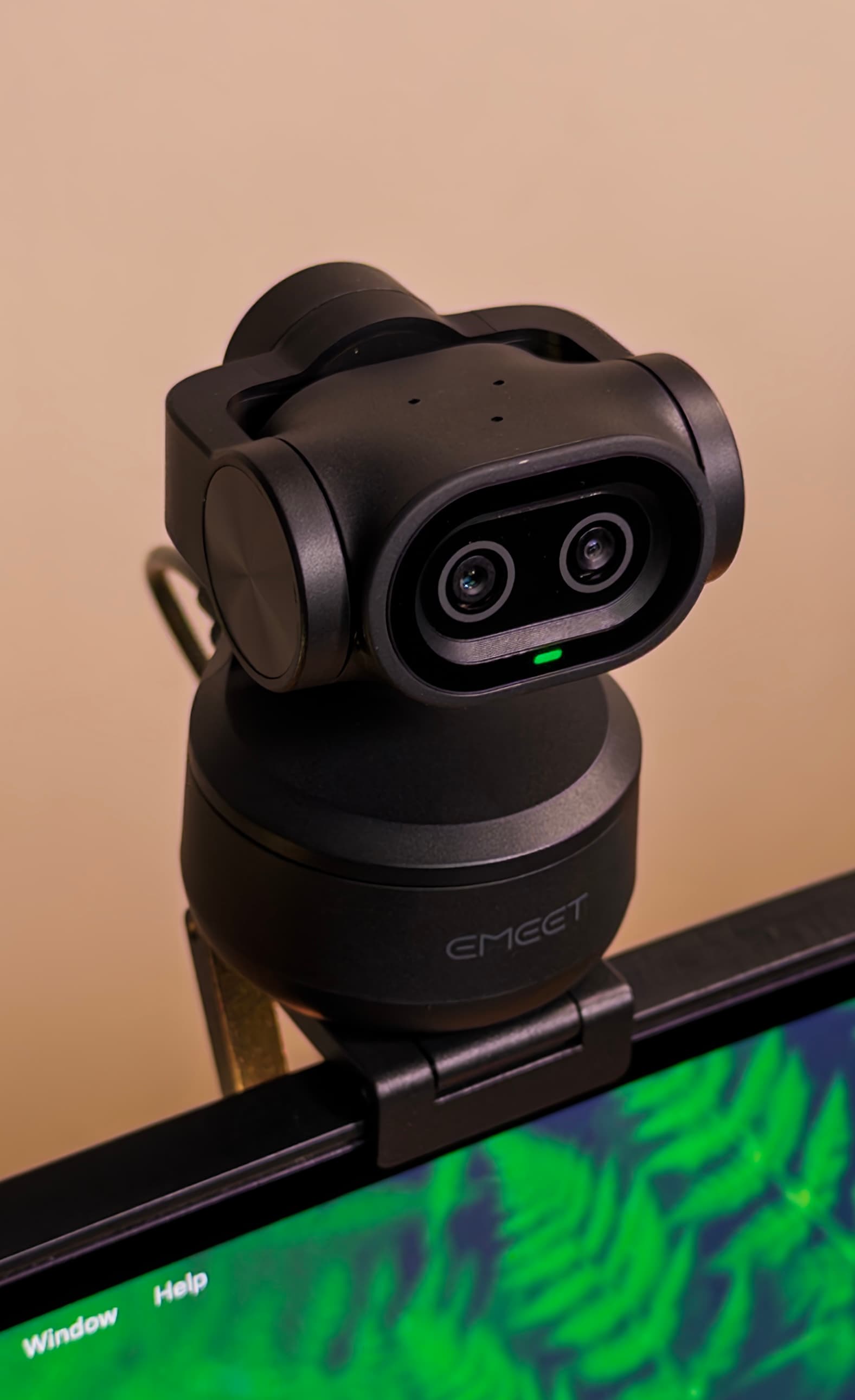 EMEET PIXY on a monitor, seen from slightly above with its head tilted toward the camera